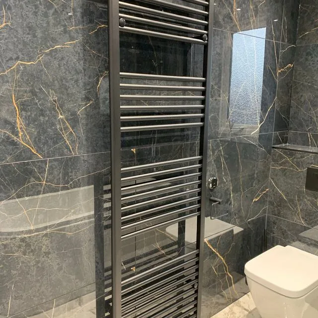 A fitted bathroom with a basin unit and heated towel rail