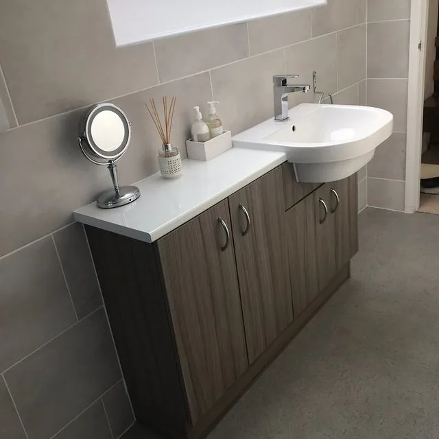 A bathroom with a shower enclosure and stone effect wall panels