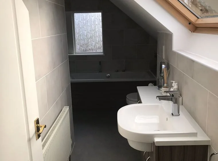 A tiled bathroom with a shower enclosure installed by JP Plumbing and Heating