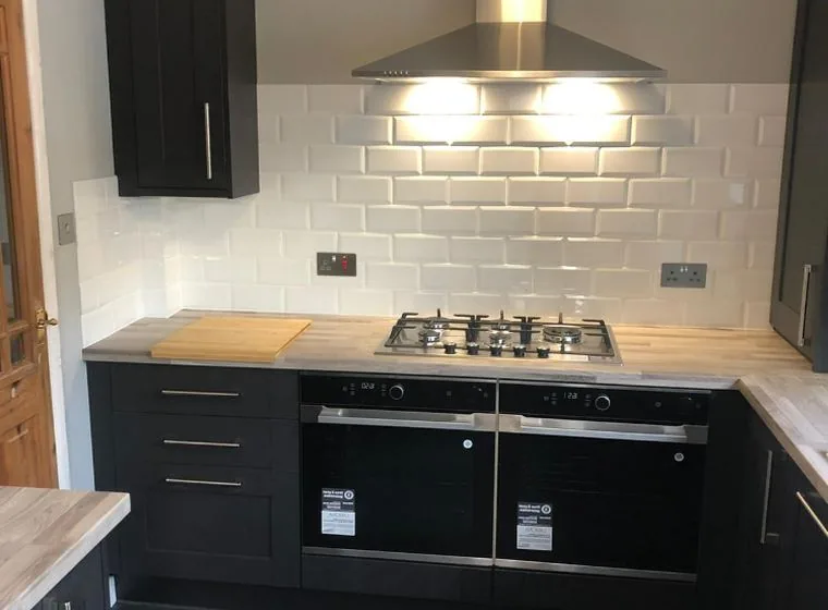 A fitted kitchen with a gas hob and extractor hood installed by JP Plumbing and Heating