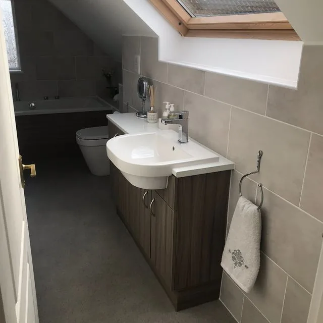 A fitted bathroom with a basin unit, toilet and heated towel rail
