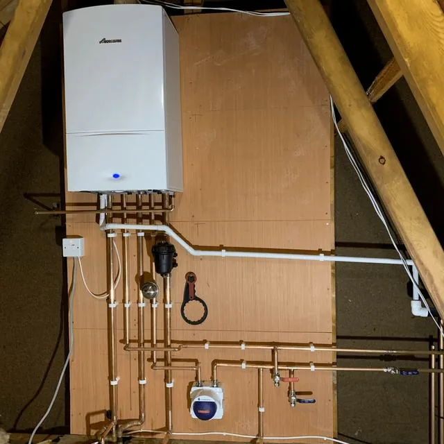 A loft boiler installation with copper pipework and an isolation valve