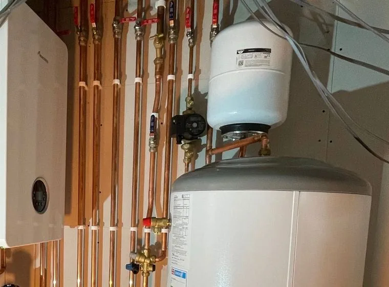 A boiler and hot water cylinder with valves and copper pipework