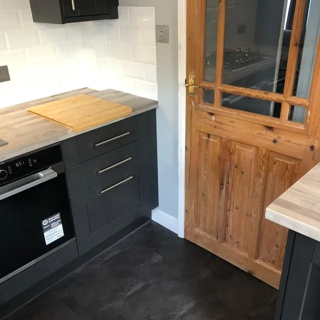 A kitchen with a wooden worktop and fitted appliances