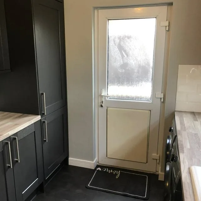 Fitted kitchen units with a wooden worktop and integrated oven