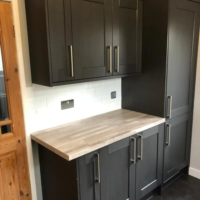 A kitchen worktop with a sink and tiled splashback