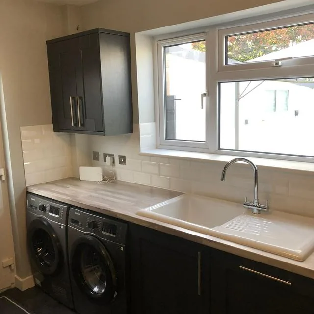 A kitchen sink and mixer tap plumbed in beside a washing machine